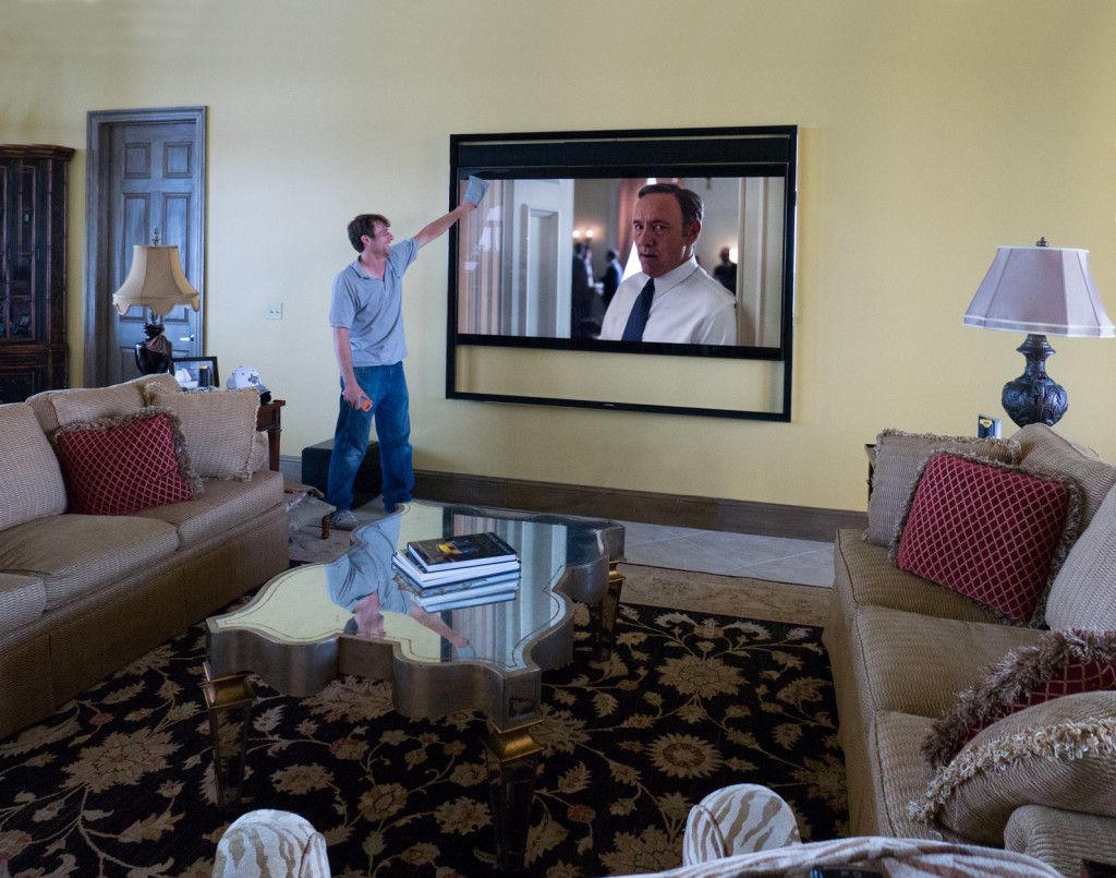Off the Wall Technician putting the finishing touches on the installation of the Samsung UN85S9 85" Flat Panel. House of Cards plays in full 4K resolution streaming from Netflix.